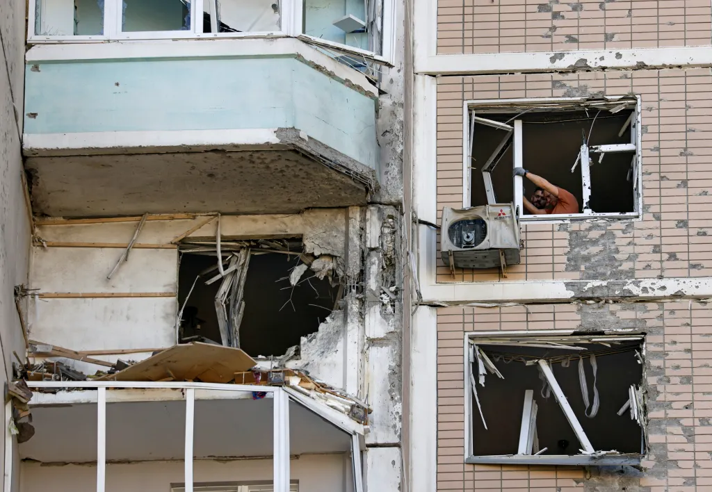Residents clear broken windows in a damaged apartment building in Krasnogorsk, Moscow region, following a Ukrainian drone attack.