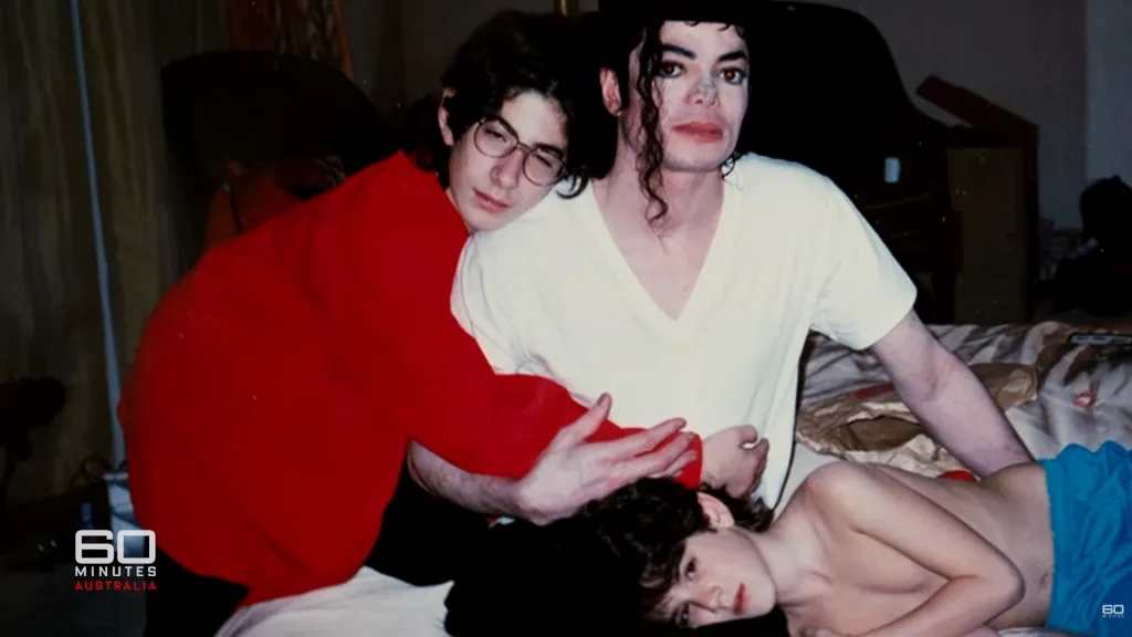 Michael Jackson and two young boys pose for a photo.