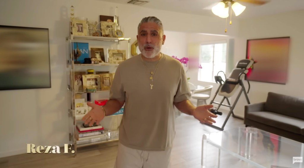 Reza Farahan standing in his home, gesturing with his hands.