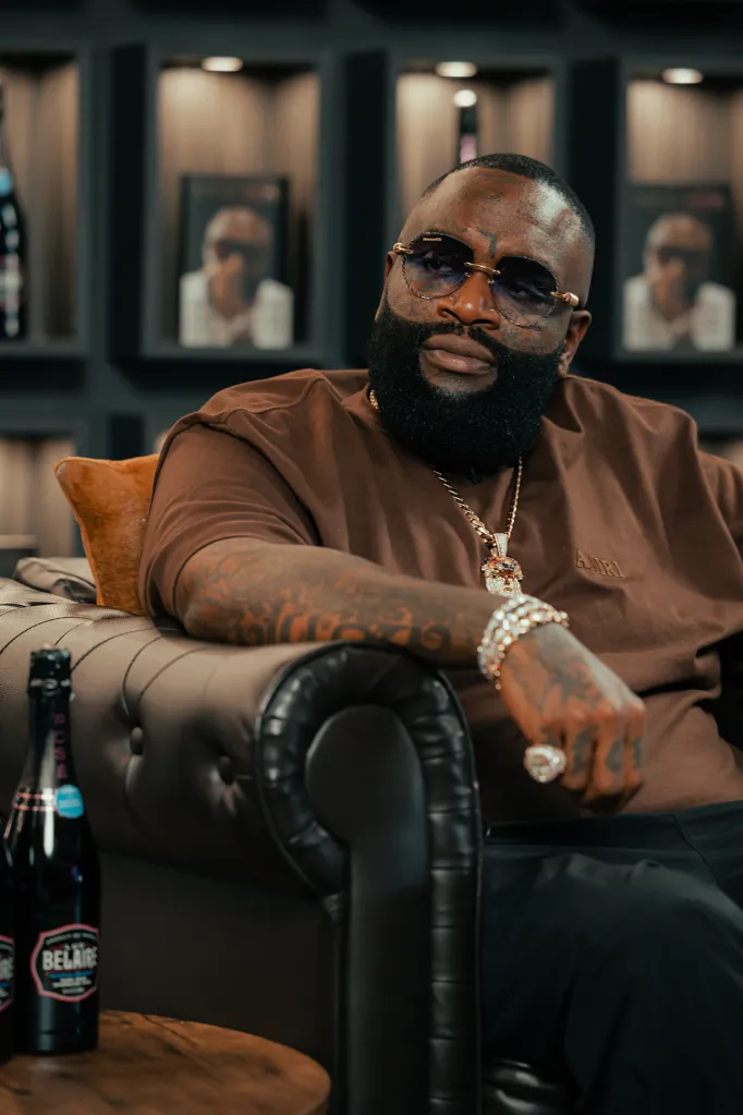 Rick Ross sitting on a couch.