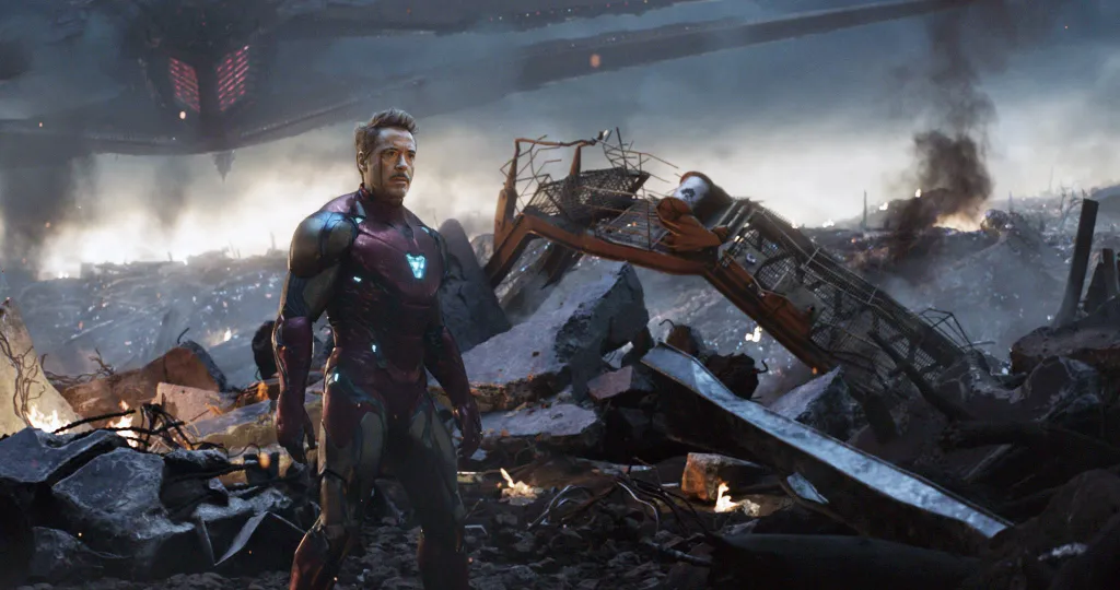 Robert Downey Jr. as Tony Stark/Iron Man in a battle-damaged landscape.