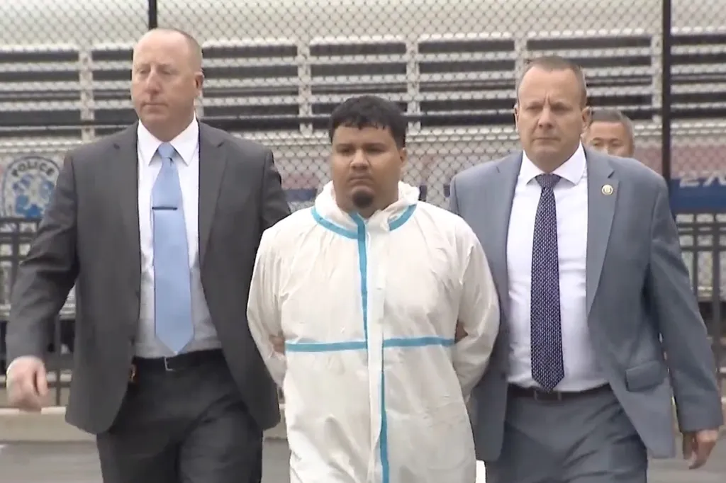 Rony Yahir Alvarenga Rivera, in a white suit, escorted by two men in suits.