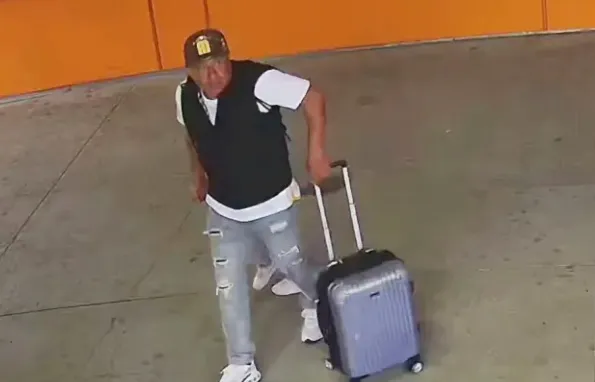 Ruben Fregoso pulls a suitcase in a parking garage.