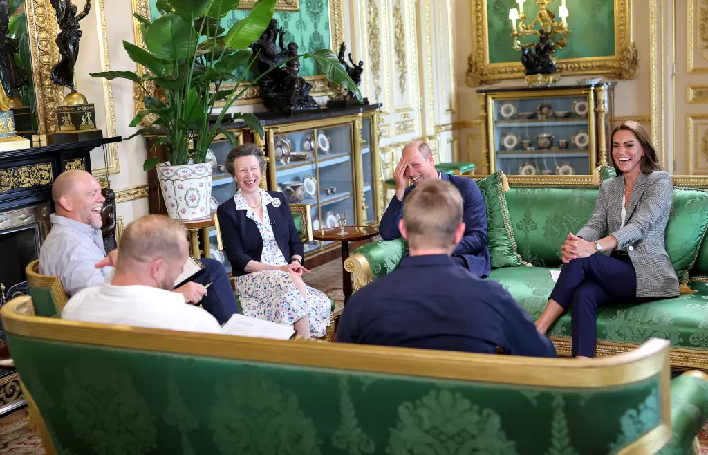Mike Tindall, Princess Anne, Prince William, and Catherine, Princess of Wales, seated and laughing during a podcast recording at Windsor Castle.