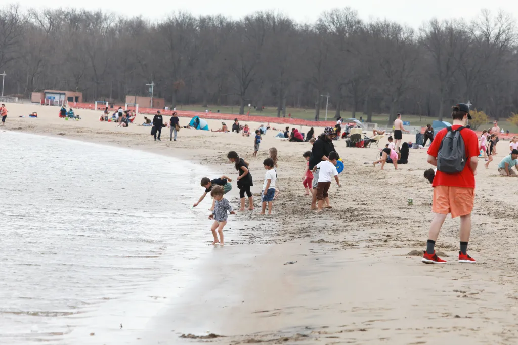 People walk around Orchard Beach.