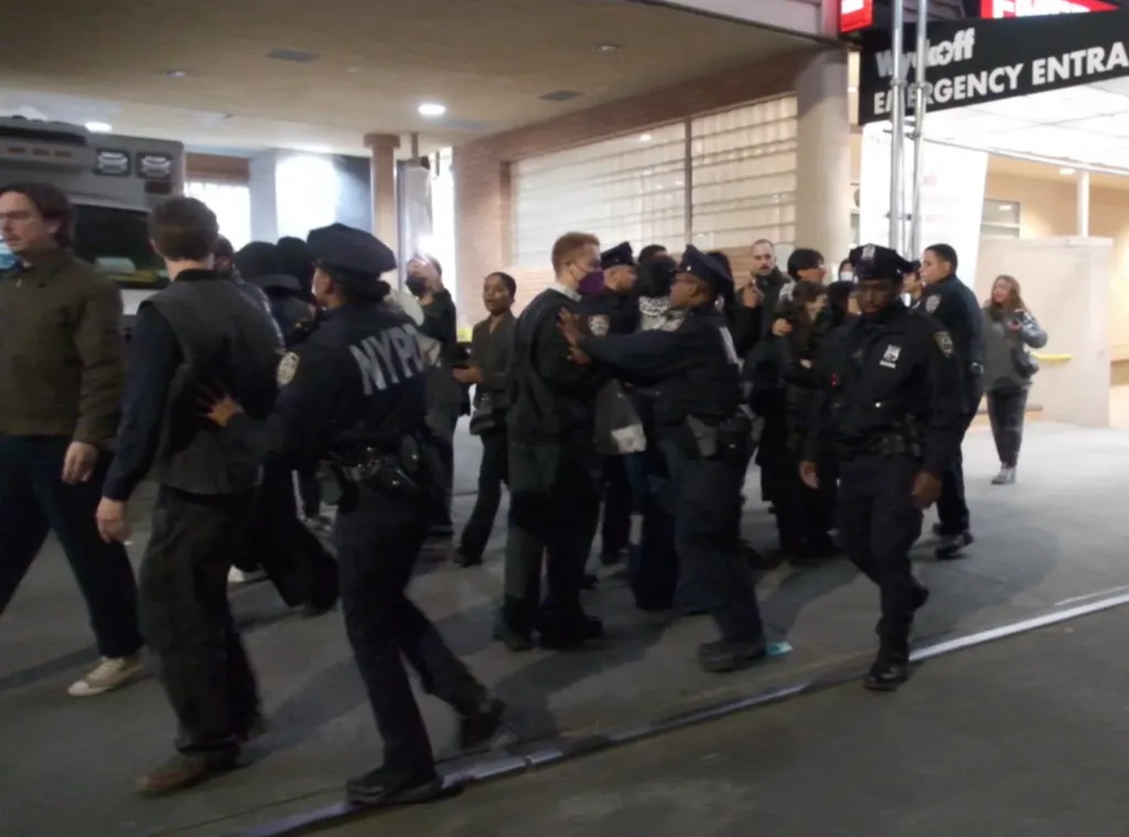 Police officers and protesters outside Wyckoff Hospital, where ICE officers removed a man from custody.