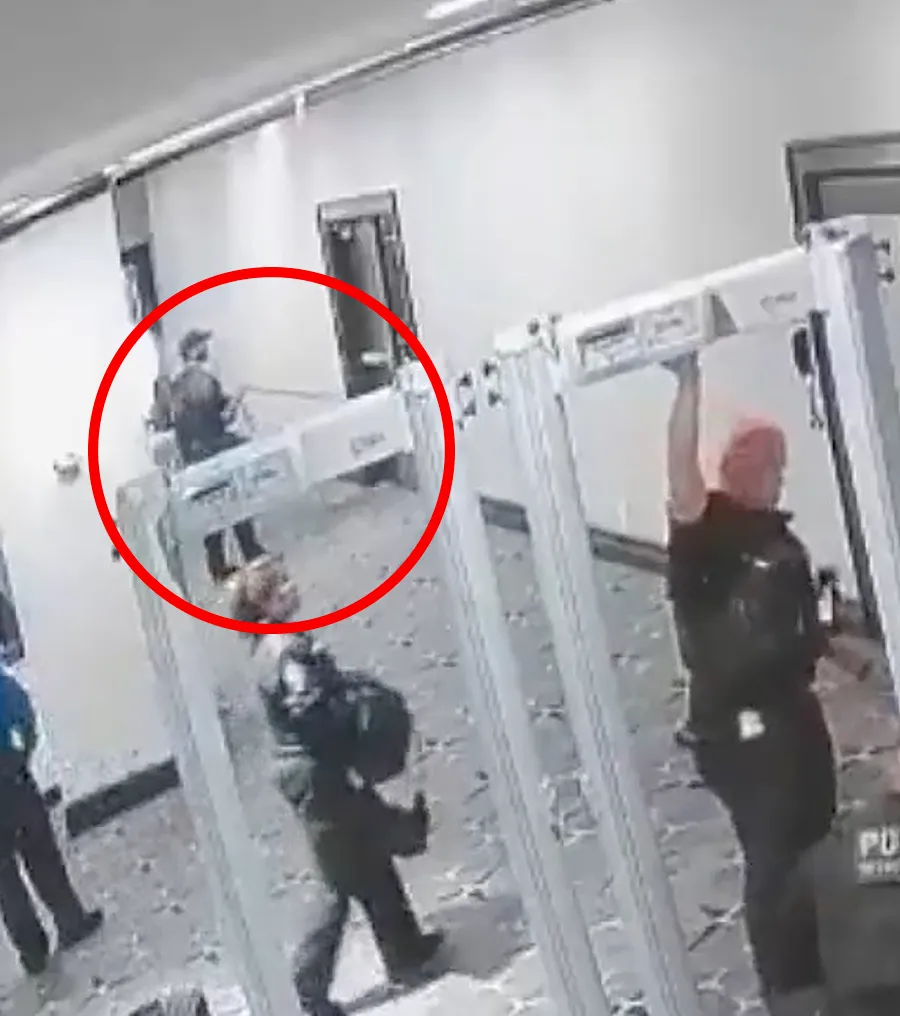 Screen grab from a video showing Cole Allen running through a hotel security checkpoint during a shooting incident.