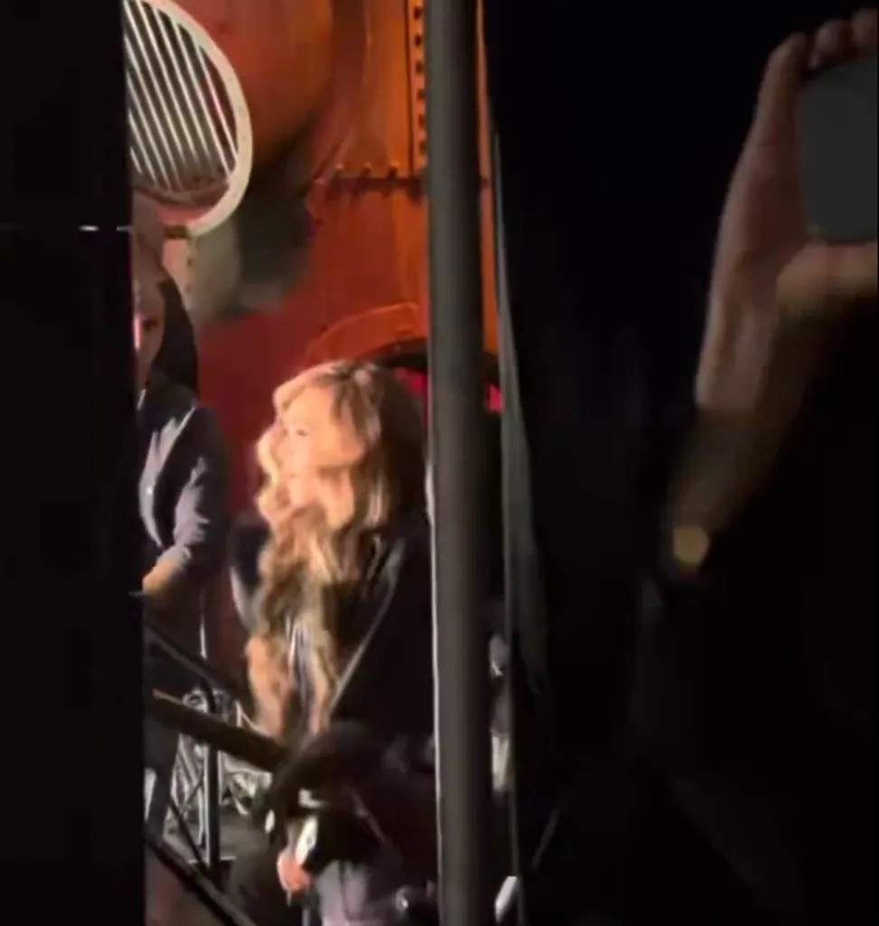 Beyoncé with long wavy hair, in a dark setting, looking to the side.