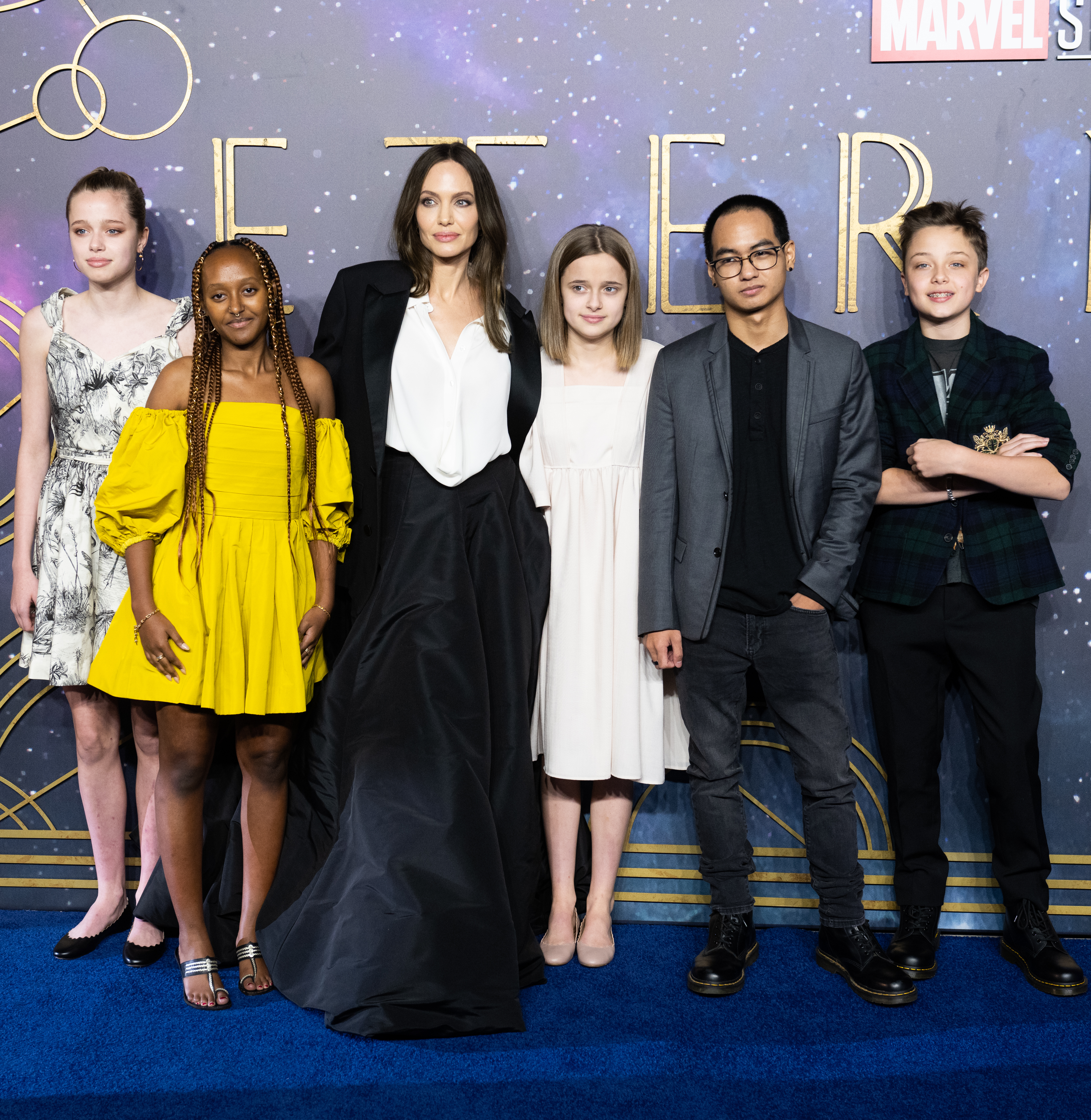Angelina Jolie and five children on a blue carpet.