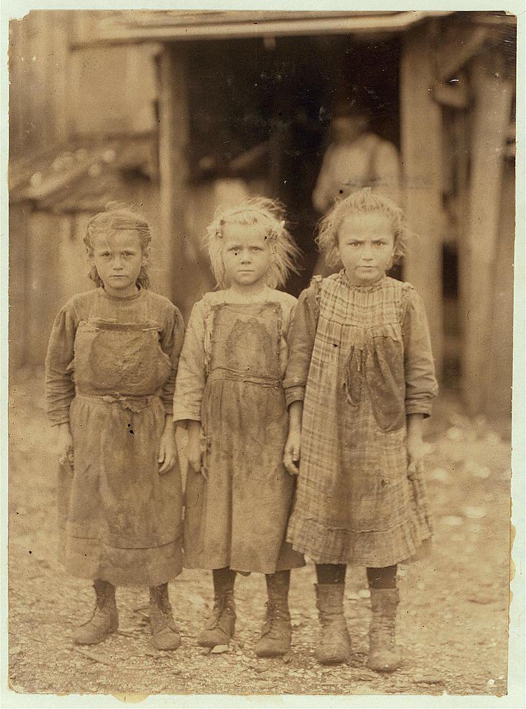 Three young girls, Josie, Bertha, and Sophie, standing in work clothes at Maggioni Canning Co.