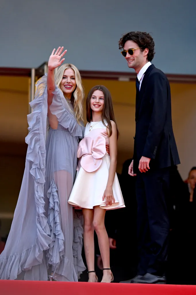 Sienna Miller, Marlowe Sturridge, and Oli Green pose on the red carpet at the Cannes Film Festival.