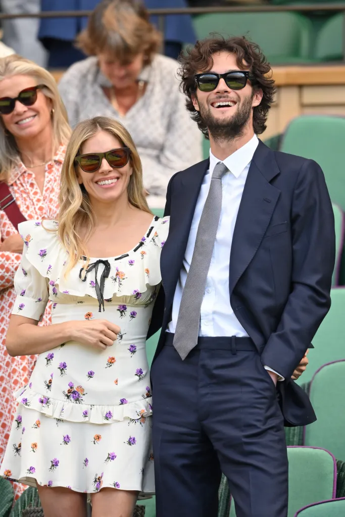 Sienna Miller and Oli Green smiling at Wimbledon.
