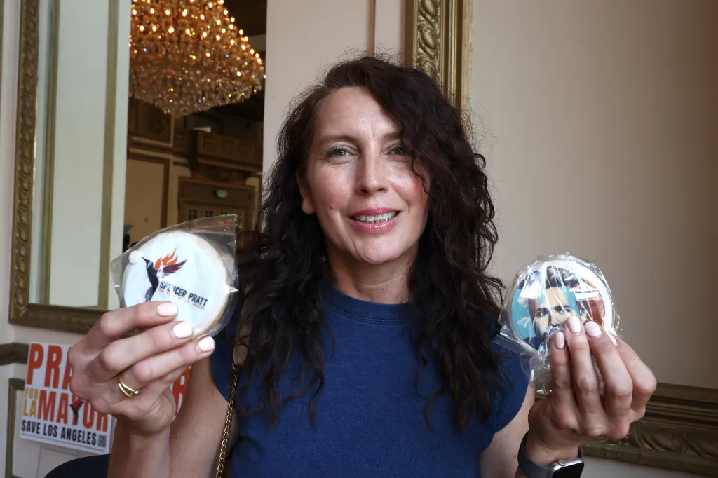 A woman holding two cookies, one for