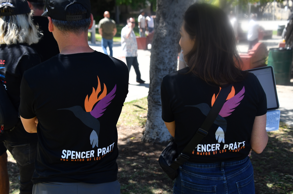 The back of two people wearing black t-shirts with a hummingbird design and the words 