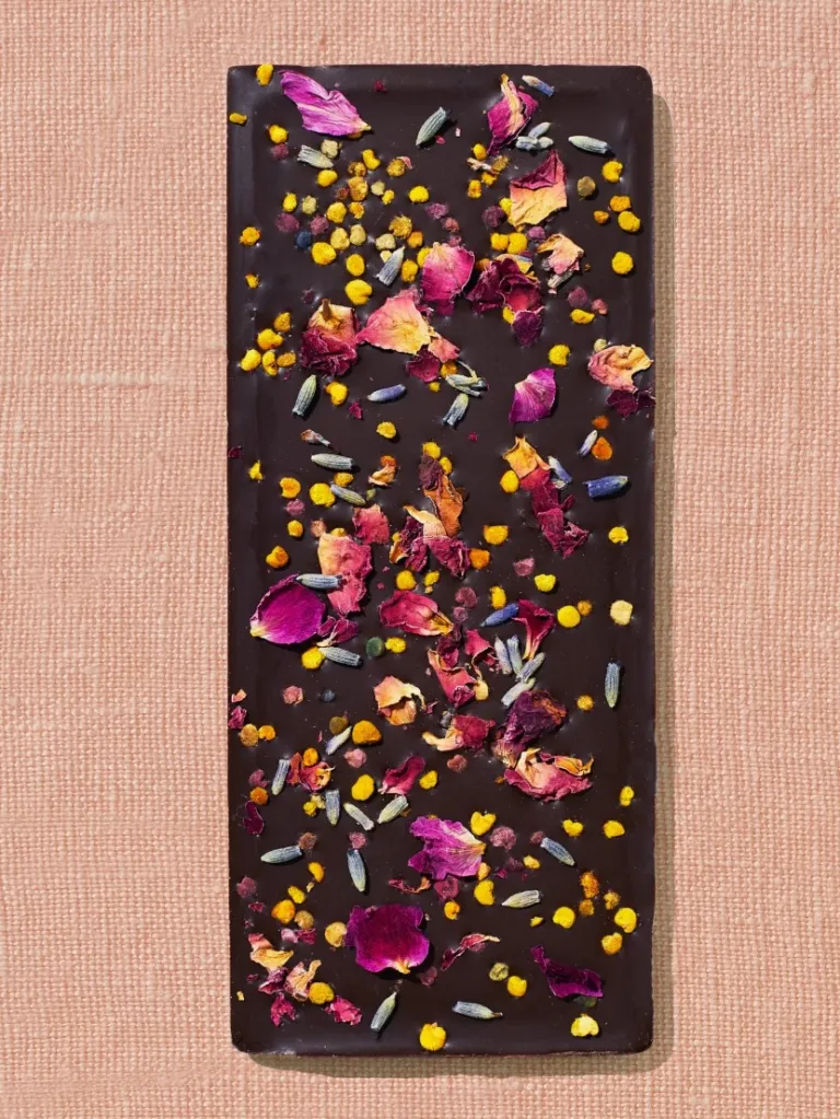 Dark chocolate bar embellished with dried rose petals, lavender, and yellow bee pollen.