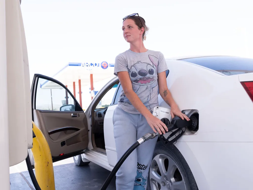 A woman pumps gas at an Arco station in Mohave Valley, Arizona.