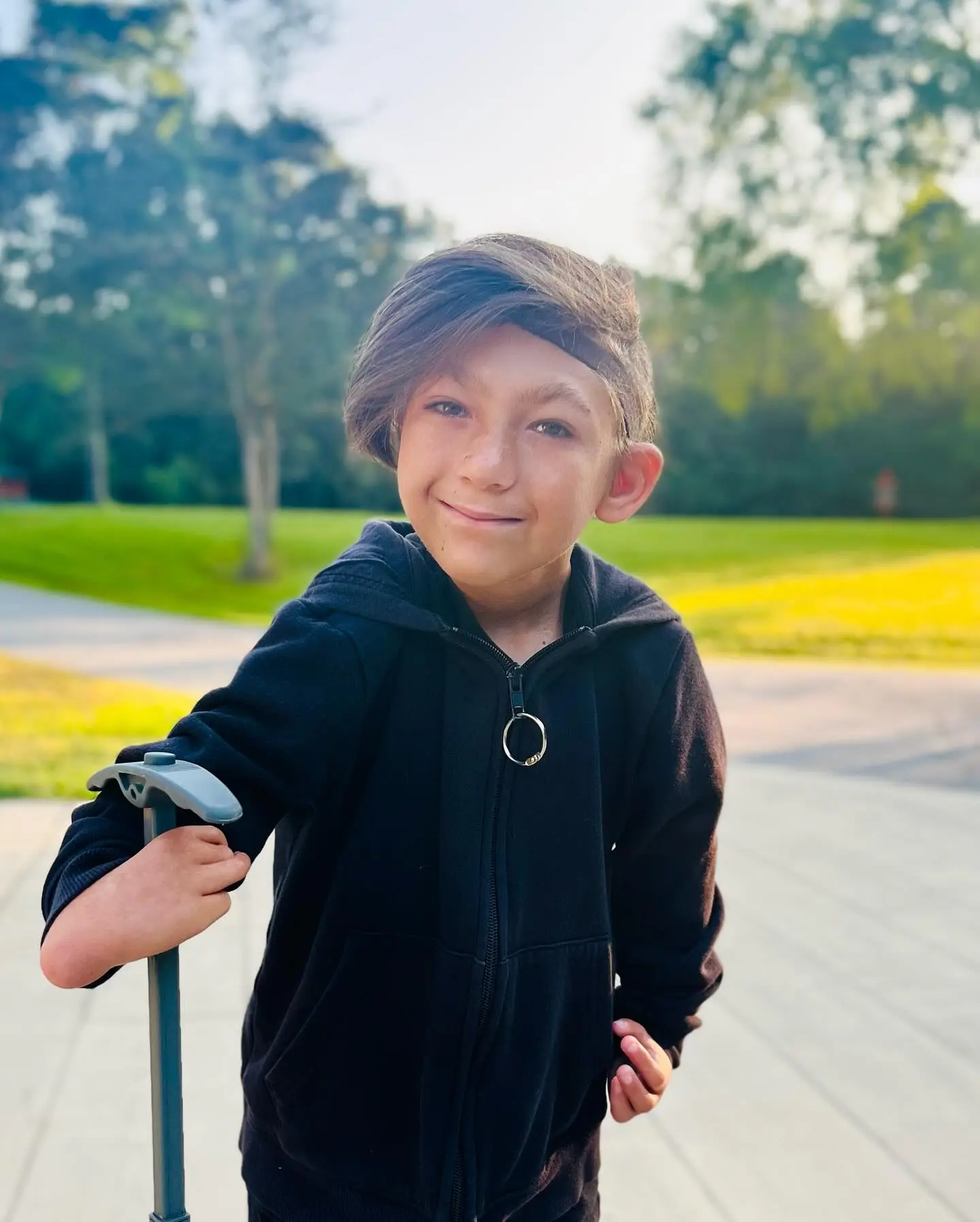 Isaac smiles while holding a cane.