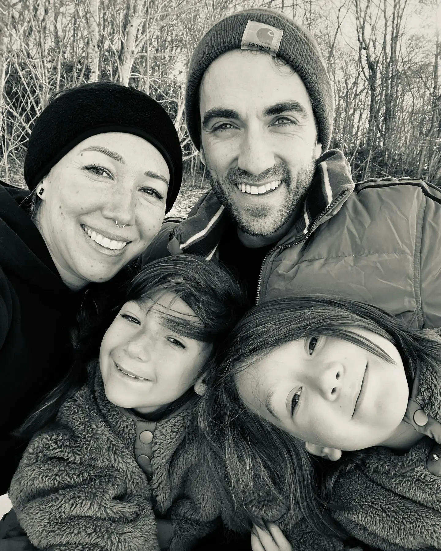 Black and white photo of Daniel Coleman, his wife, and their two sons smiling.