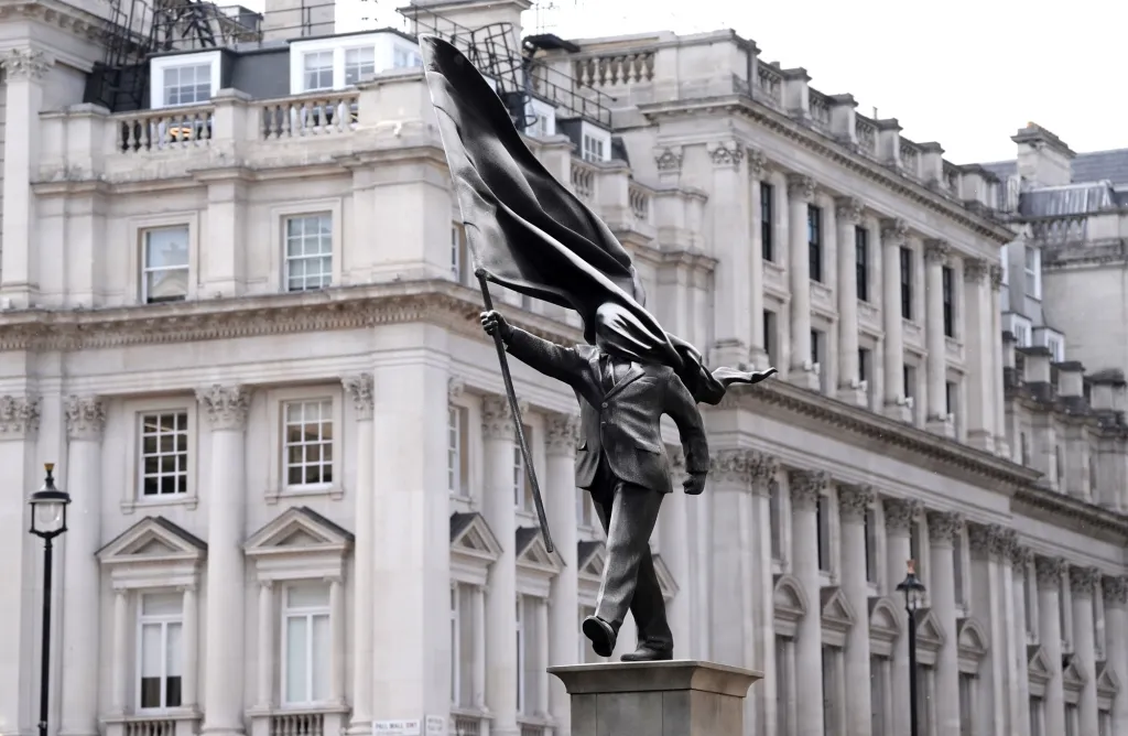 Banksy statue of a man holding a flag that obscures his face, in London.