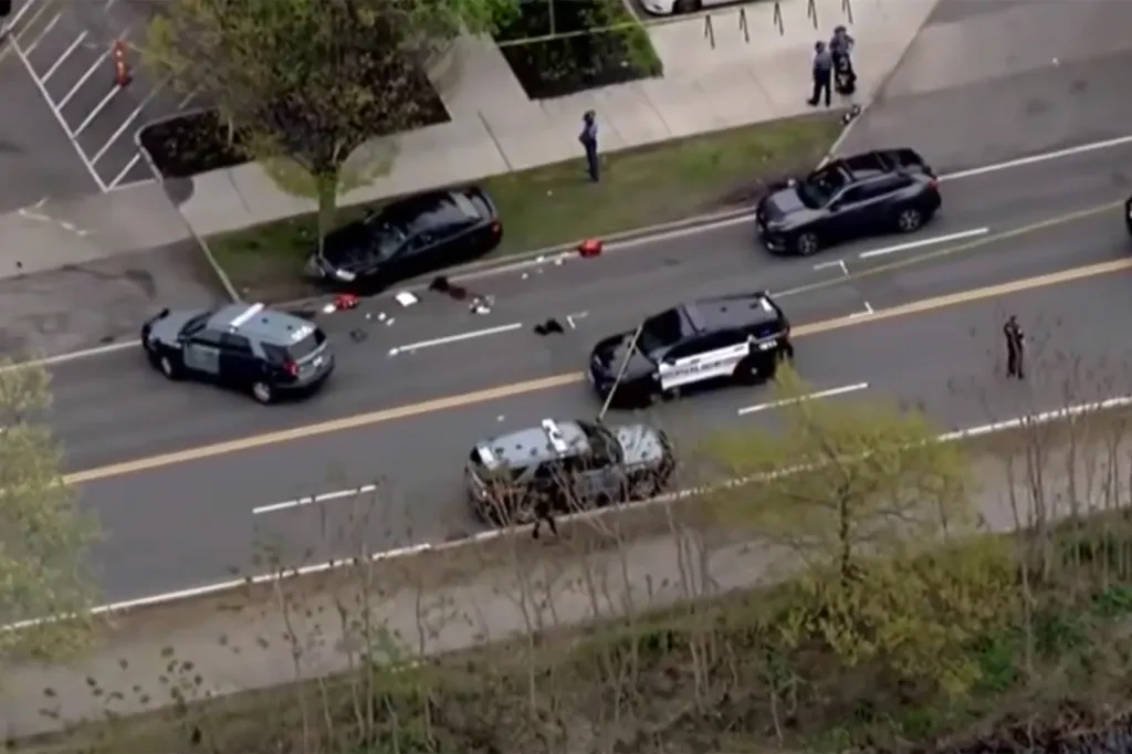 Overhead view of a street with multiple police vehicles and debris scattered on the road, with officers standing nearby.