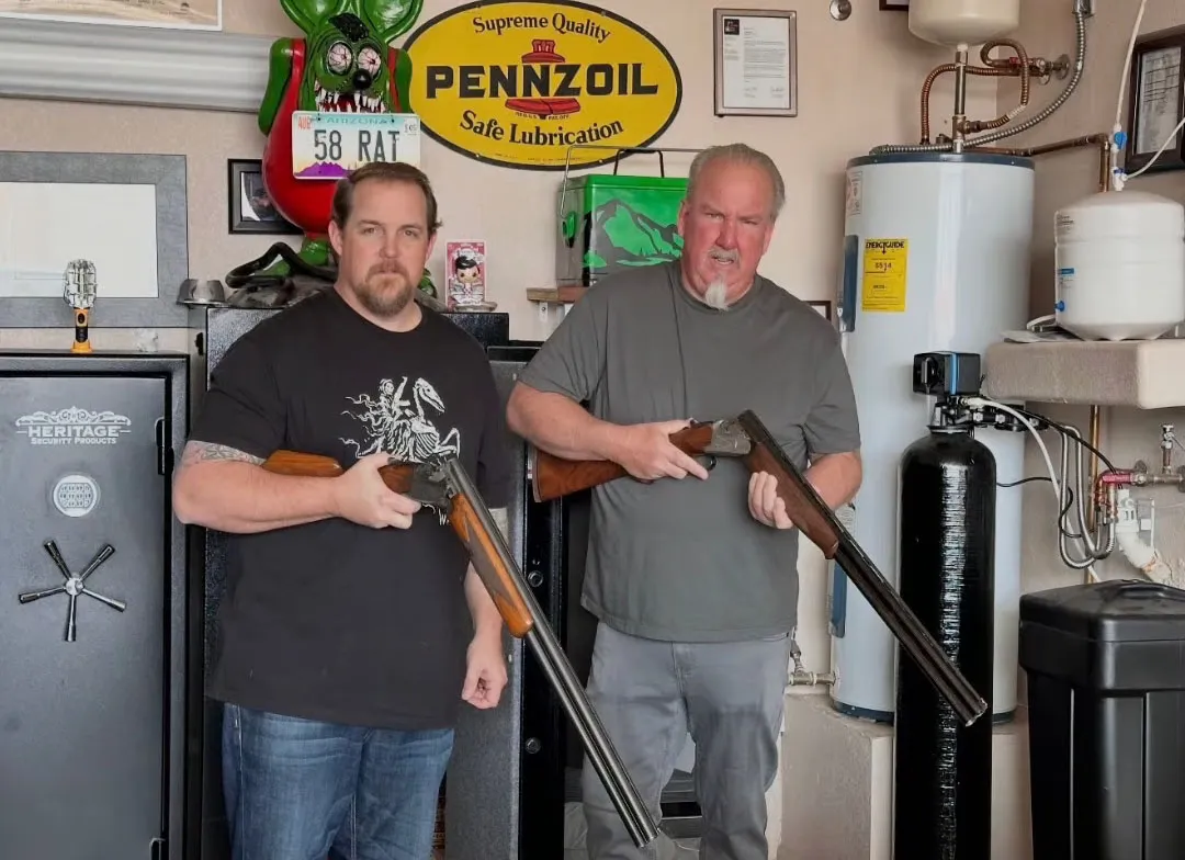 Brandon and his father Darrell, both holding shotguns, pose for a social media photo.