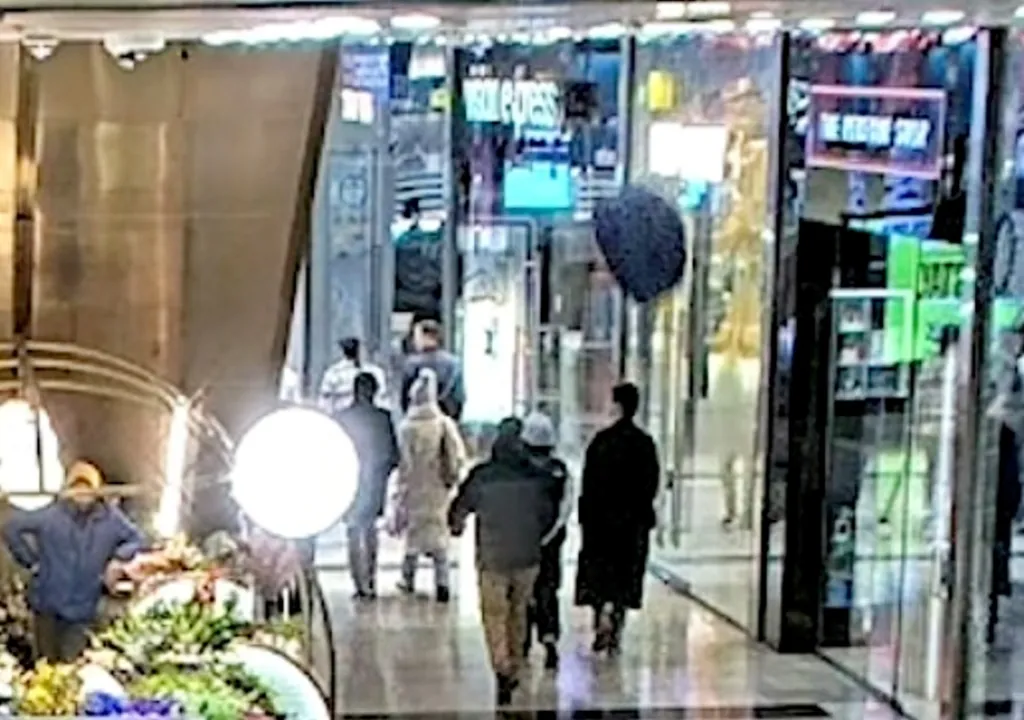 CCTV footage shows a black object falling from a high balcony towards shoppers in a mall.