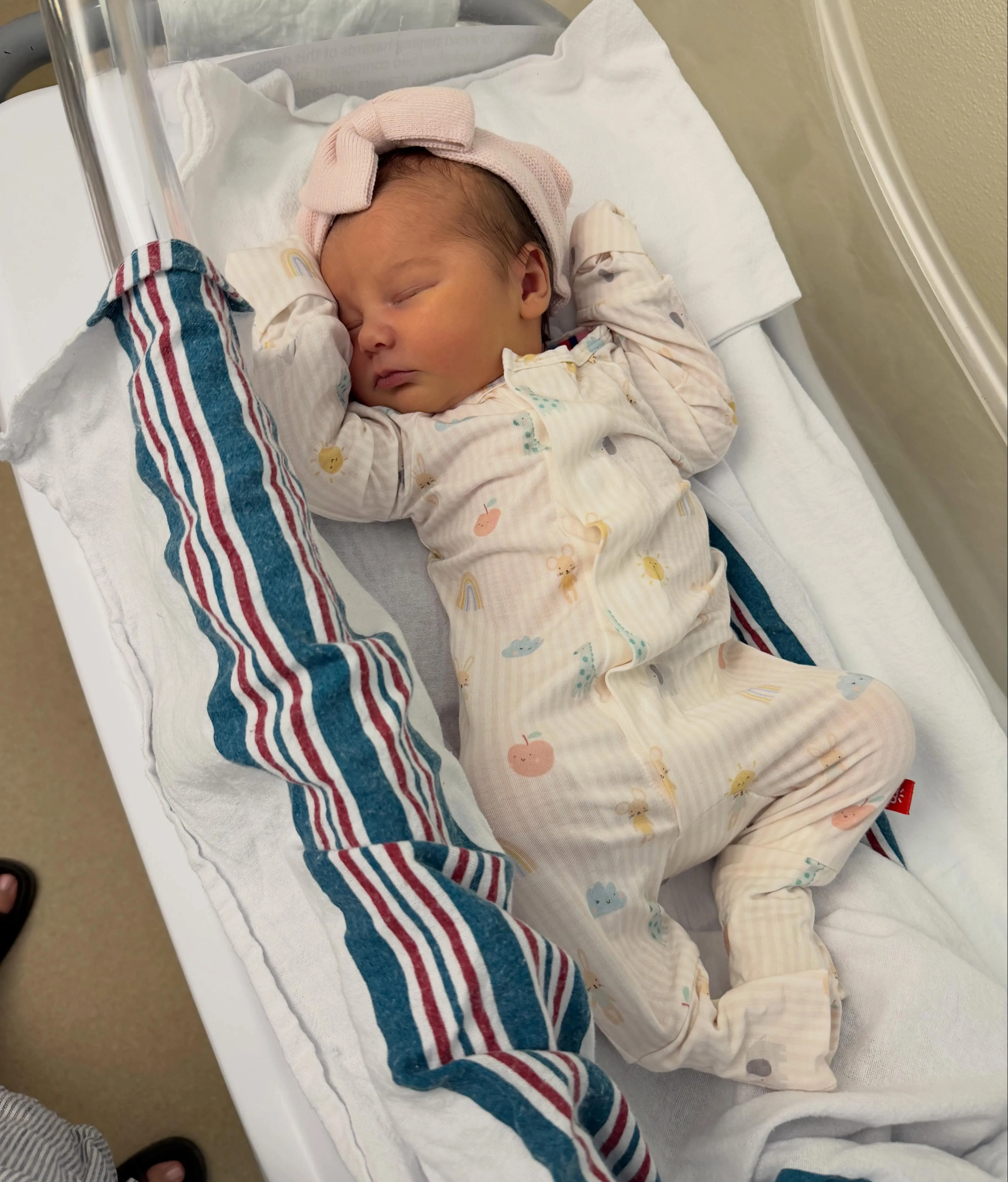 Newborn baby Selene sleeping in a hospital bassinet.