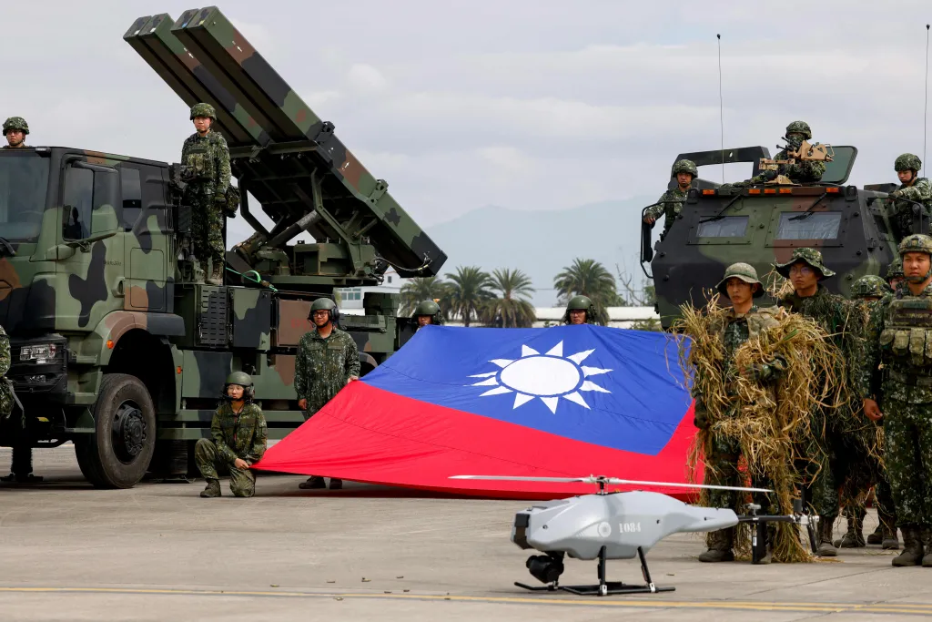 Taiwanese soldiers pose with a Taiwanese flag, Sky Sword II missile launcher, and military UAV during an annual military exercise.