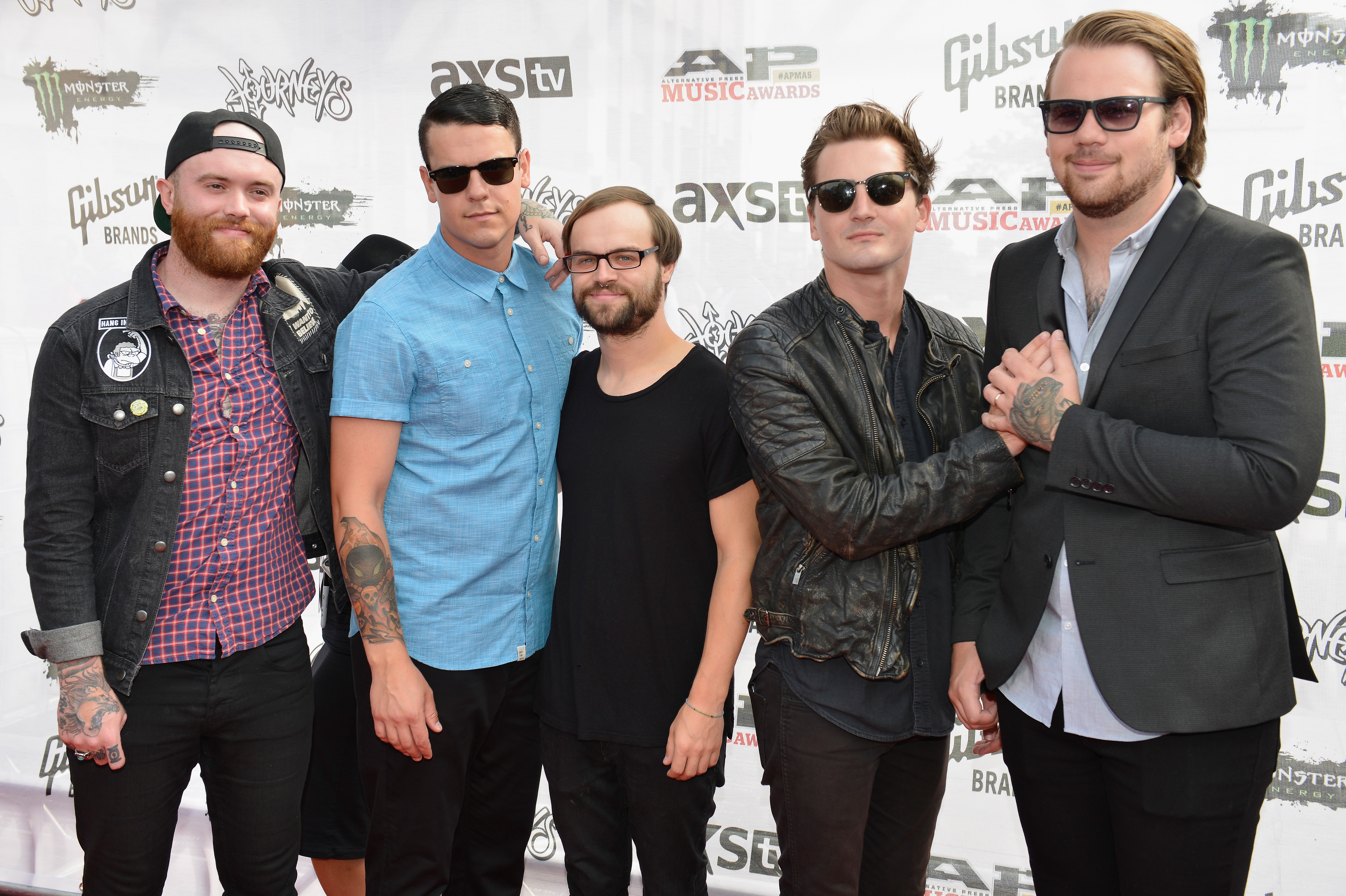 Band members Taylor Lumley, Oshie Bichar, Kamron Bradbury, Caleb Shomo, and Brandon Mullins of Beartooth posing on a red carpet.