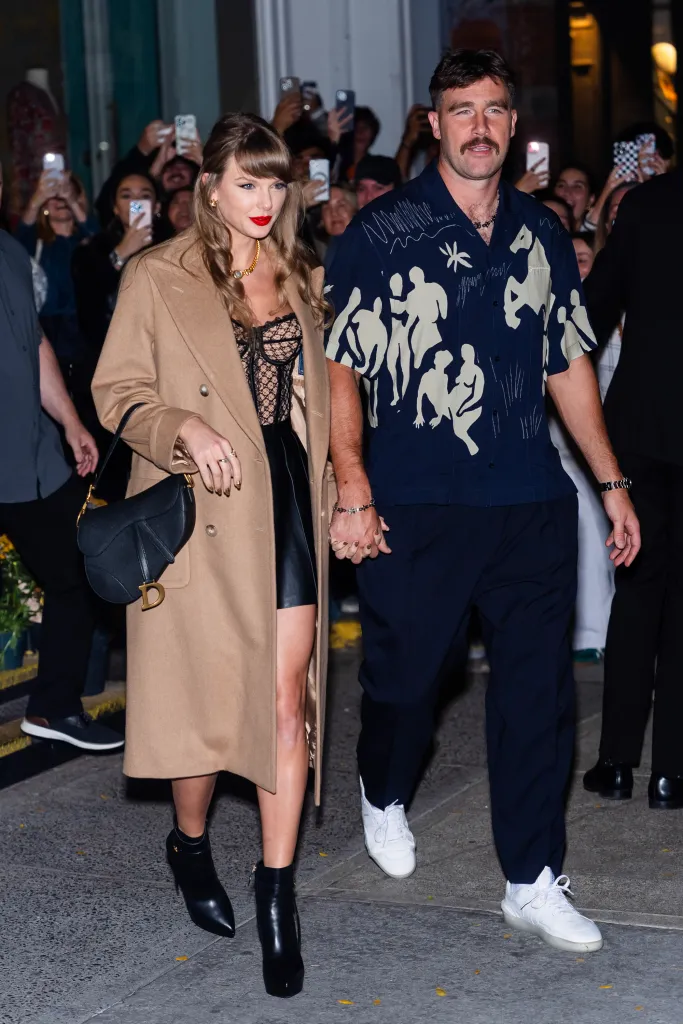 Taylor Swift and Travis Kelce holding hands while walking in New York City.
