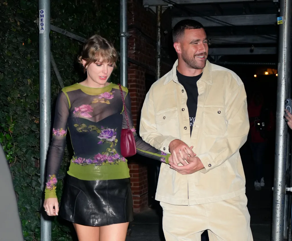 Taylor Swift and Travis Kelce hold hands while leaving dinner.