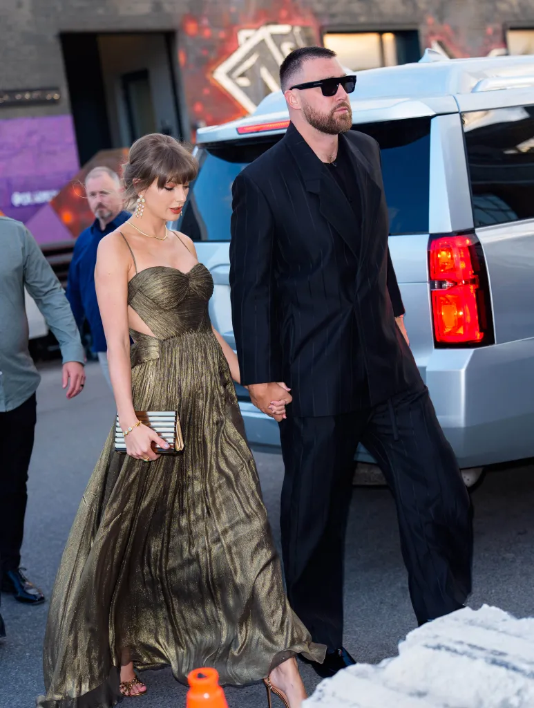 Taylor Swift and Travis Kelce holding hands while walking in New York City.