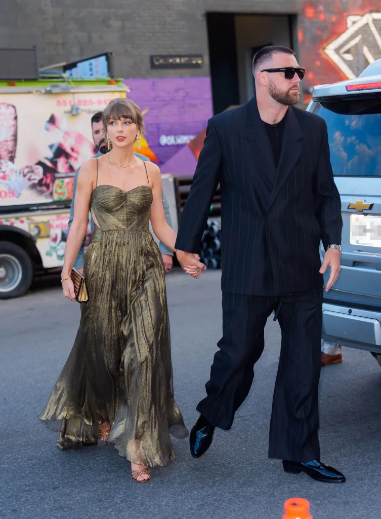 Taylor Swift and Travis Kelce holding hands while walking in New York City.