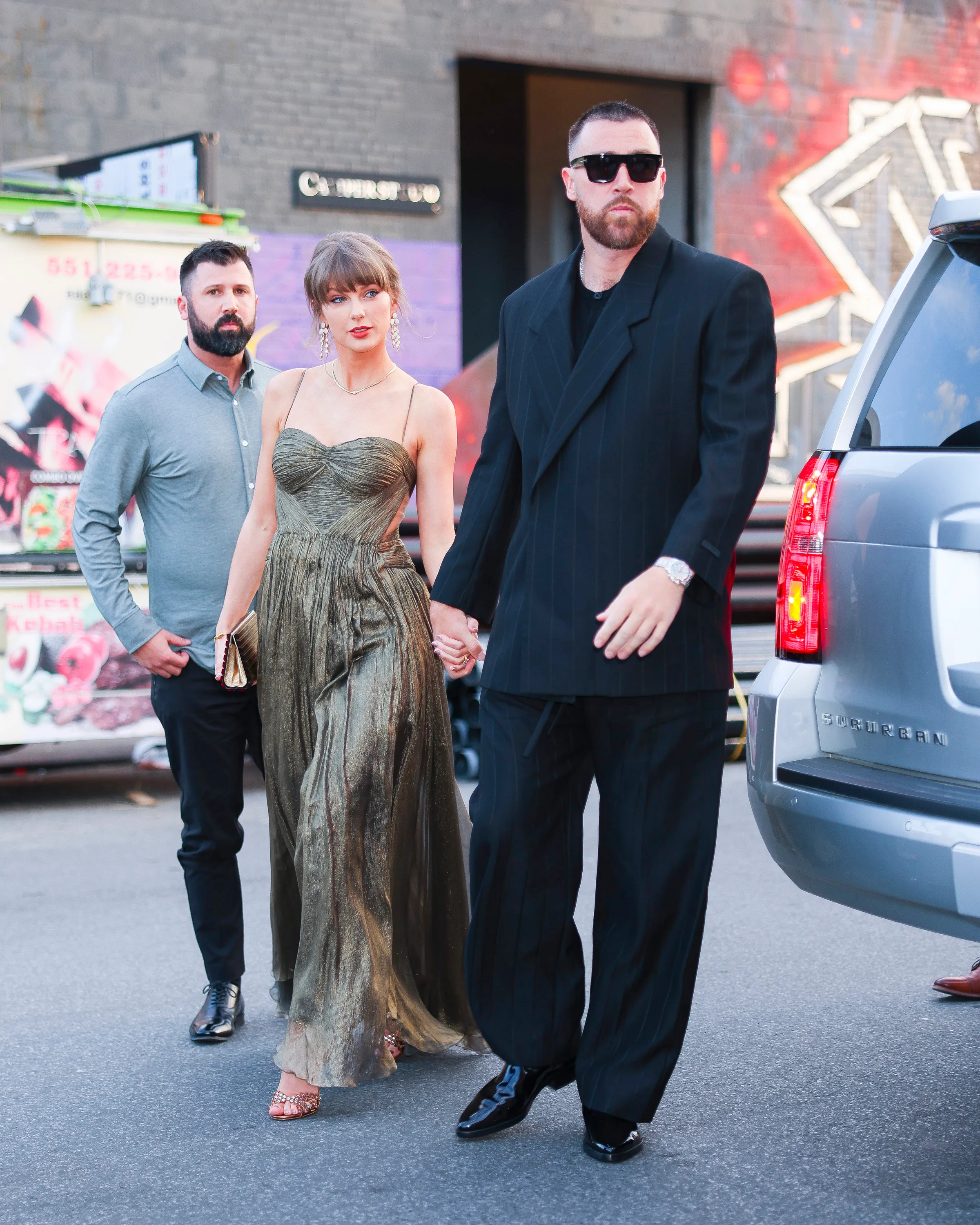 Taylor Swift and Travis Kelce holding hands while walking in New York City.