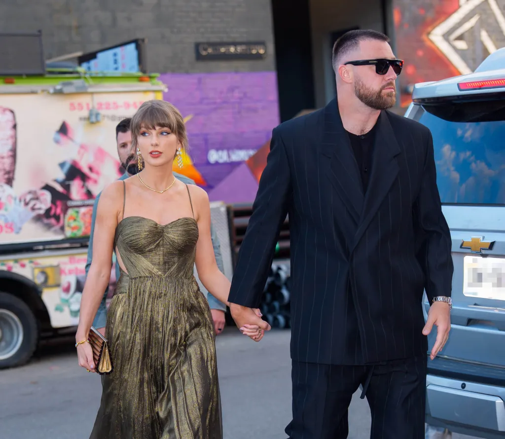 Taylor Swift and Travis Kelce holding hands while walking in New York City.