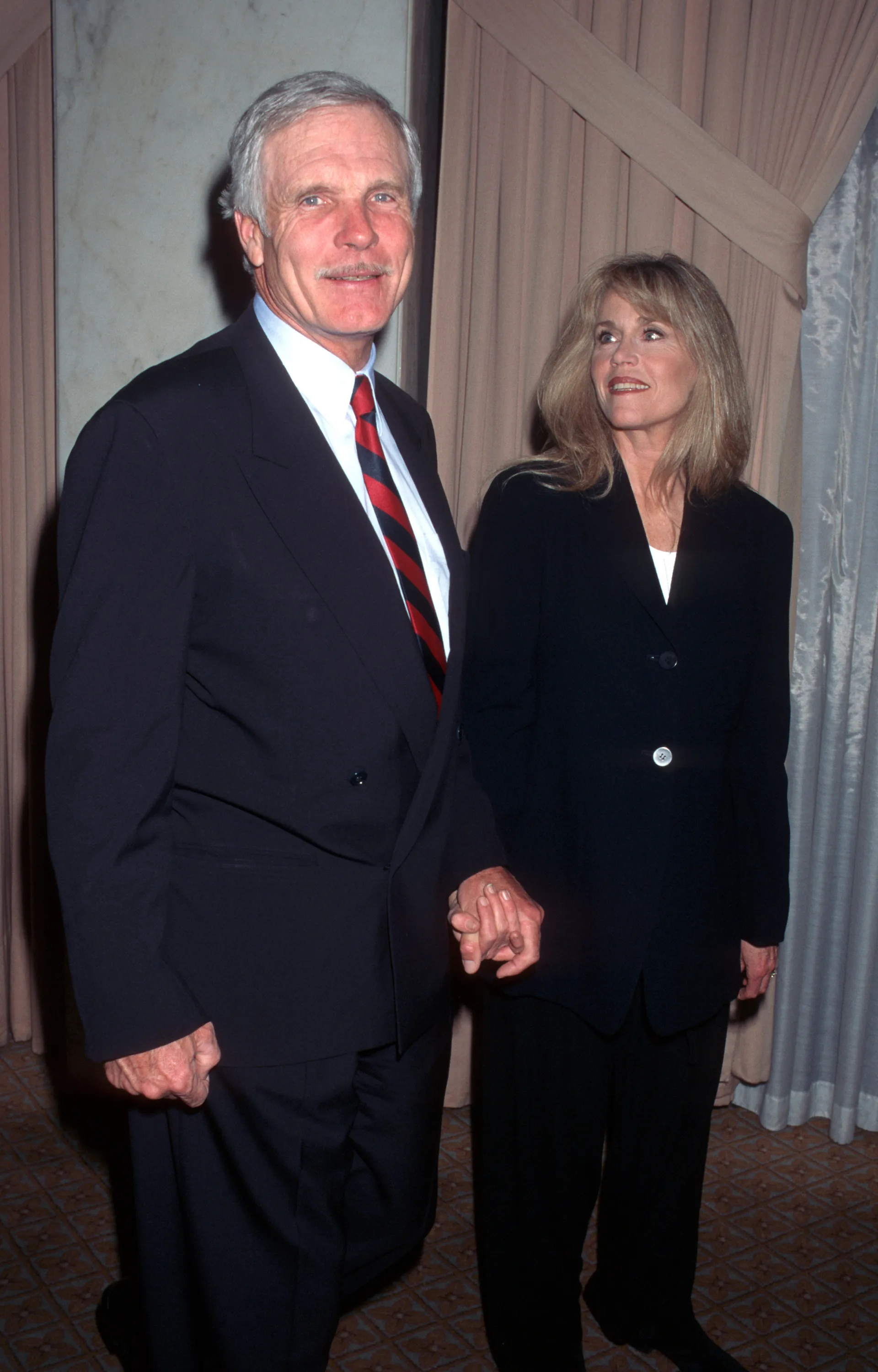 Ted Turner and Jane Fonda holding hands at the 6th Annual Producers Guild of America Golden Laurel Awards.