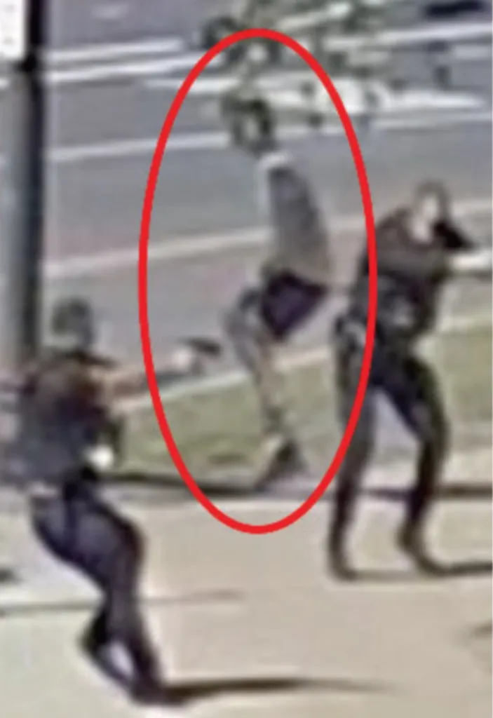 Surveillance footage of a bystander getting shot in the leg.