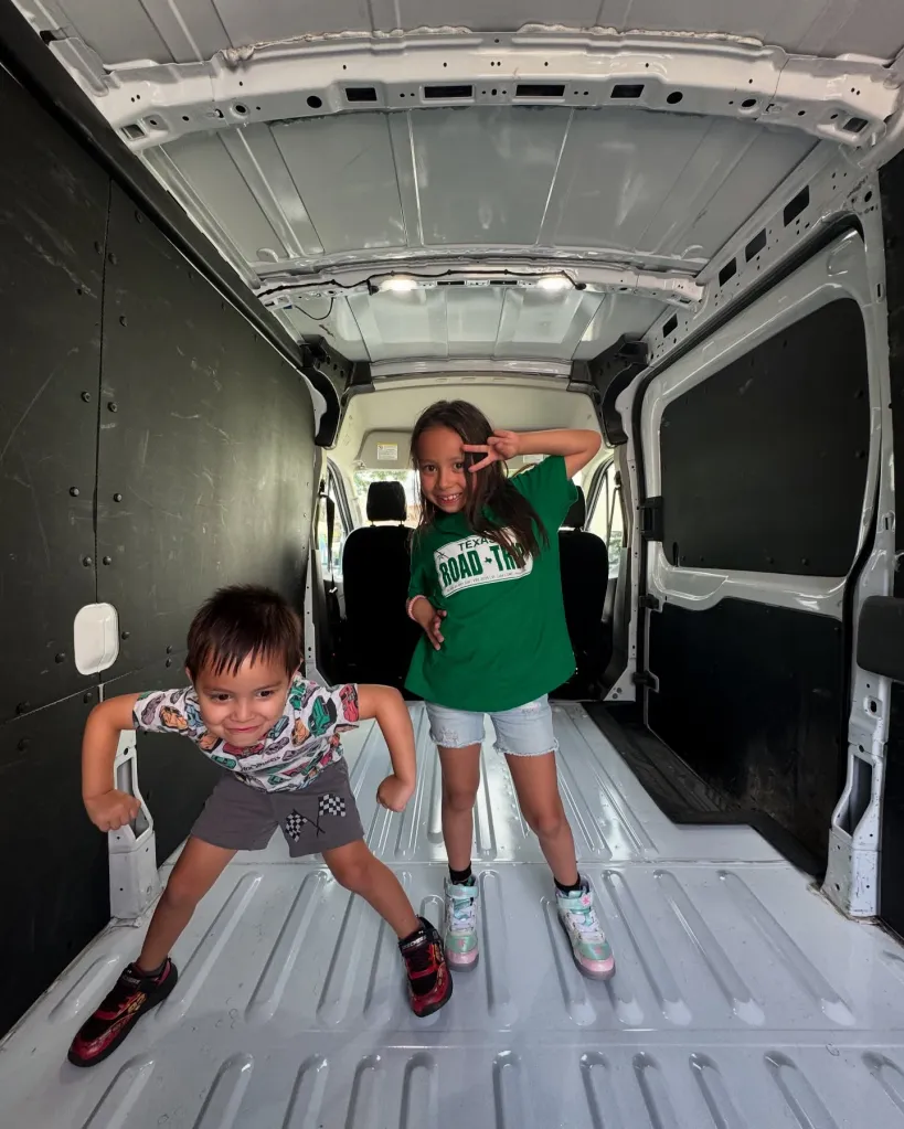 Thy and Matthew Mitchell's children posing inside a cargo van.