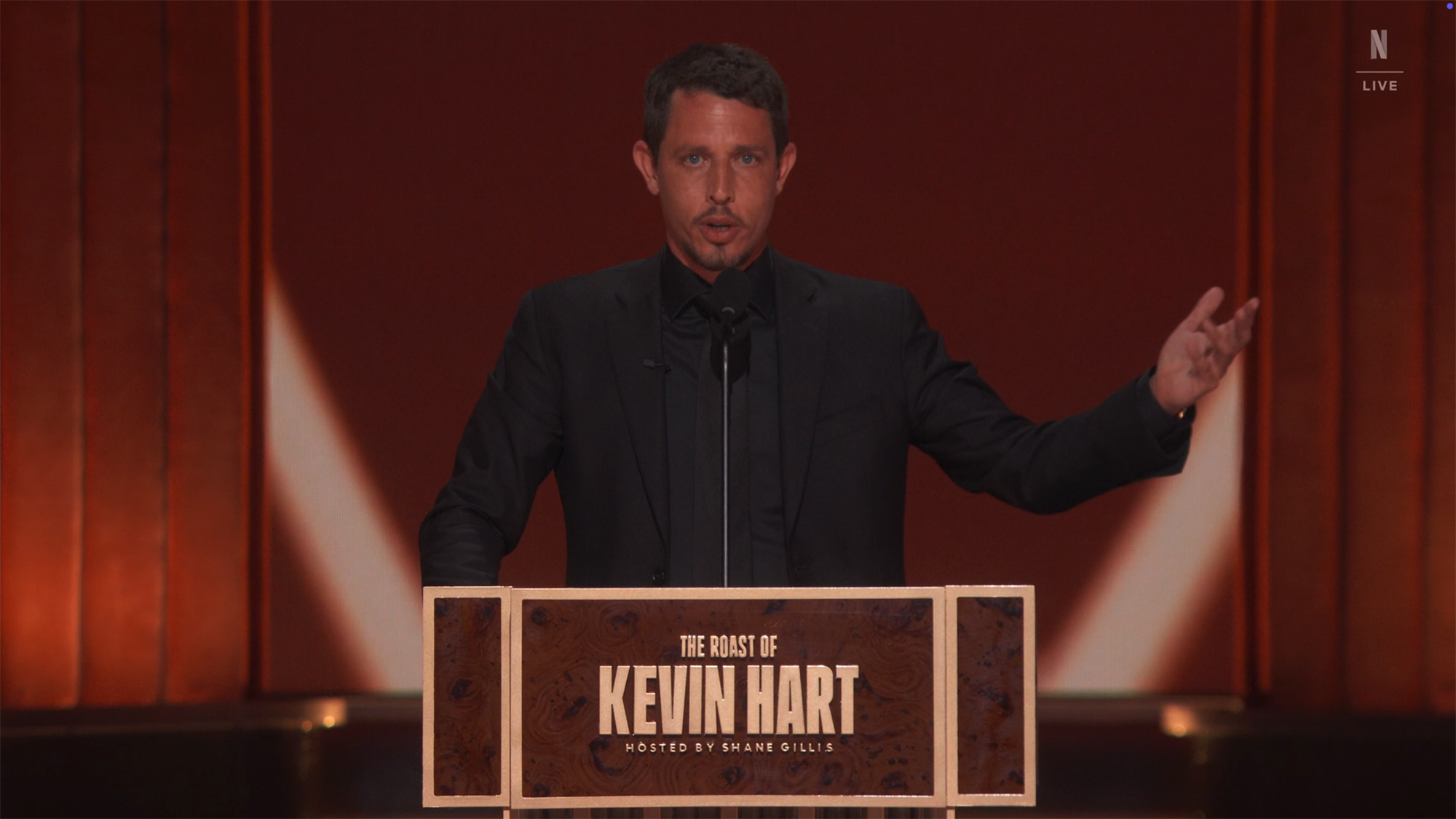 Tony Hinchcliffe standing at a podium labeled 