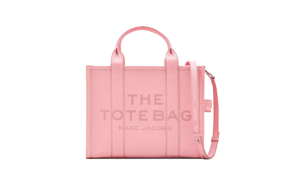 A pink handbag with a strap ona. classic tote bag. 