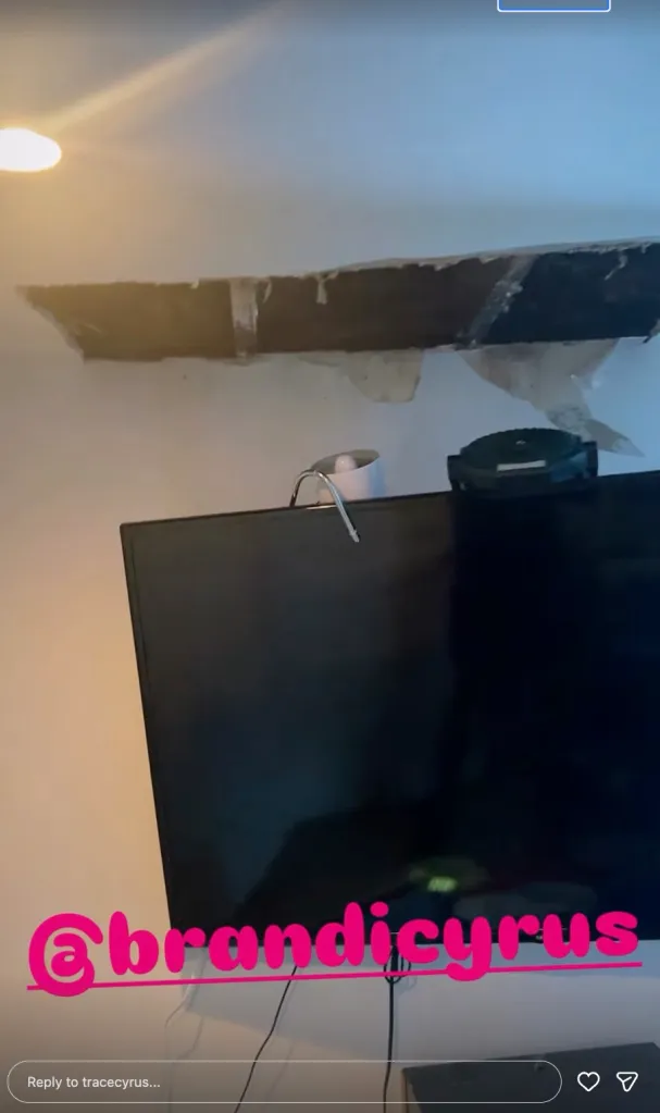 A TV is placed below a wall showing peeling paint and a black discoloration on a beam.