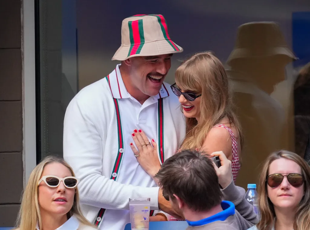 Travis Kelce and Taylor Swift smiling together at the US Open.