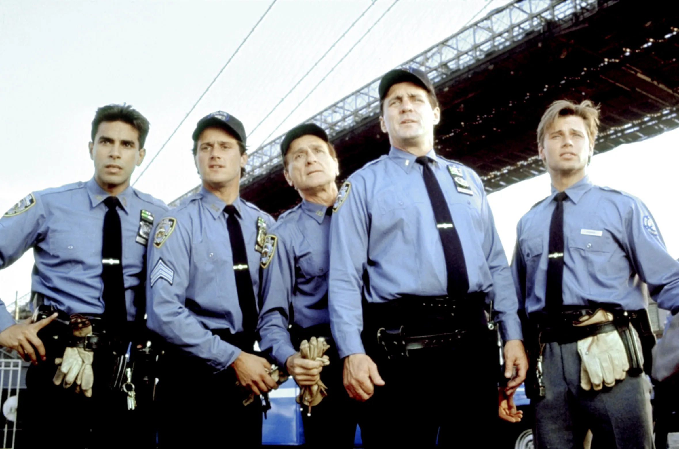 Cast photo of five actors dressed as police officers from the television series 