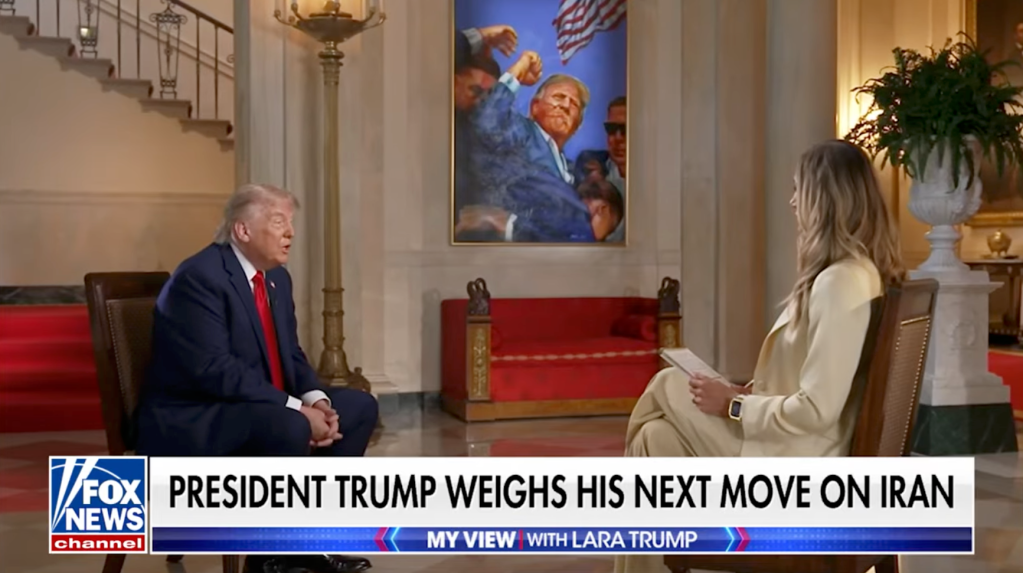 Donald Trump being interviewed by Lara Trump, with a painting of Trump boxing in the background.