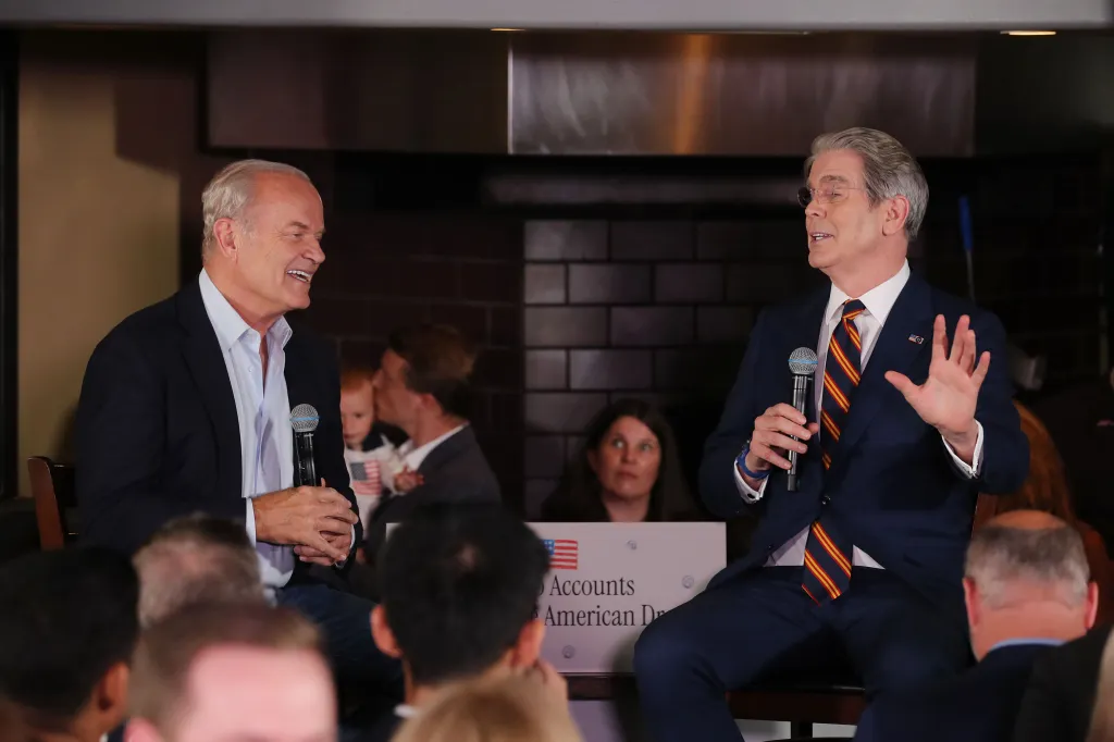 Kelsey Grammer and Scott Bessent speaking at an event, holding microphones.