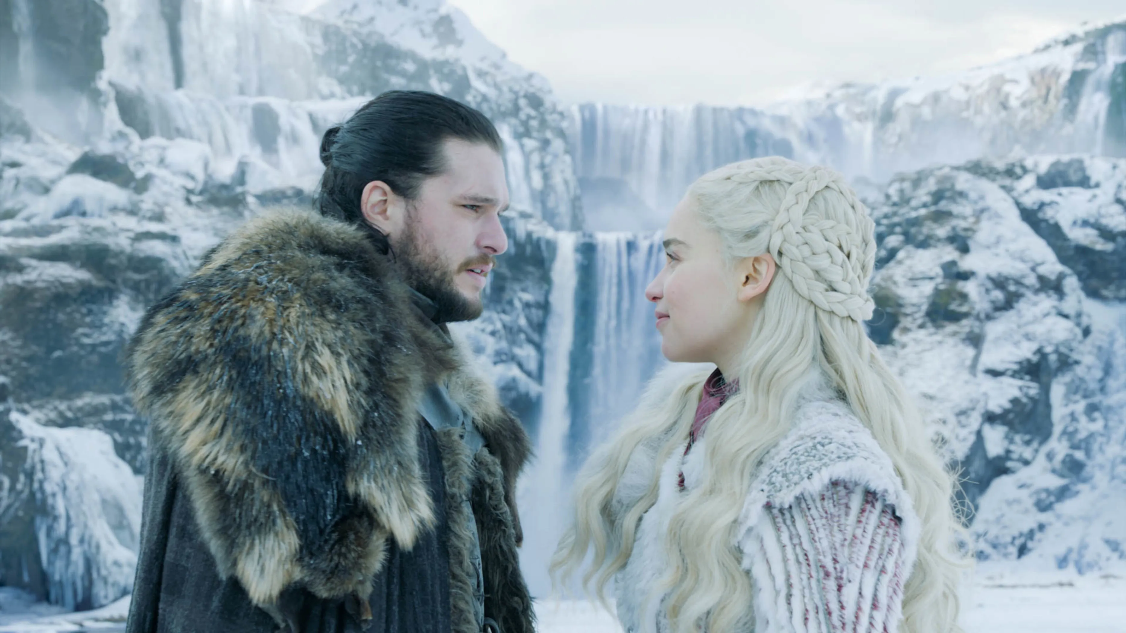 Kit Harington and Emilia Clarke from Game of Thrones in a snowy landscape.
