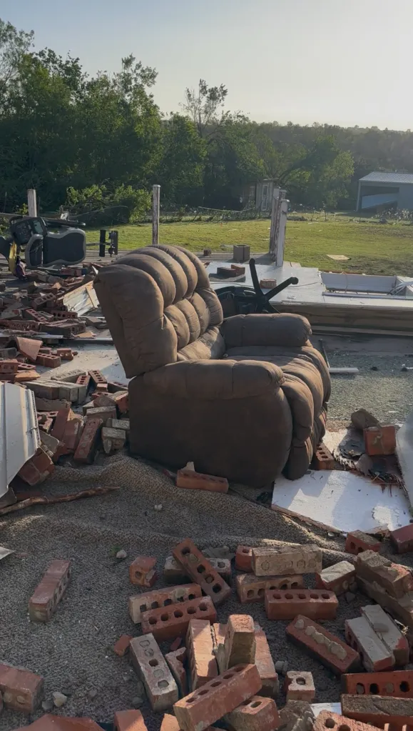 An easy chair and remnants of the inside of a home after a tornado tore through it