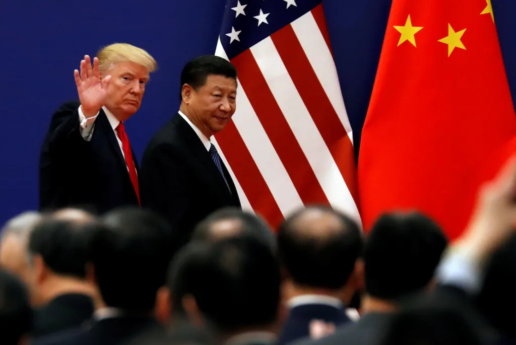 U.S. President Donald Trump and China's President Xi Jinping walk in front of American and Chinese flags at the Great Hall of the People in Beijing.