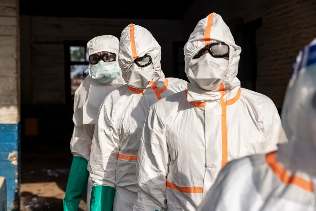 Workers line up to disinfect their protective equipment at General Referral Hospital of Mongbwalu during the Ebola outbreak response in Mongbwalu, Ituri province, eastern Democratic Republic of Congo, on May 20, 2026