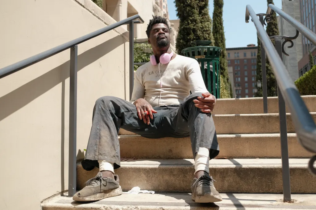A man recently released from jail sits on steps outside the Los Angeles Central Library.